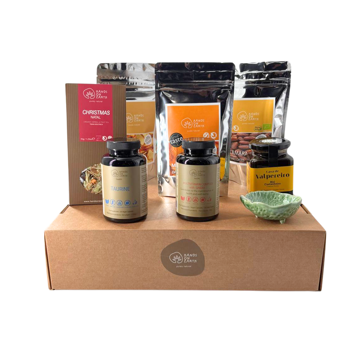 Cabaz de Natal Premium Hands on Earth com tisana de Natal biológica, tâmaras biológicas, mel de castanheiro biológico, maçã e abacaxi desidratados, suplementos alimentares, peça Bordallo Pinheiro e caixa premium com logótipo Hands on Earth